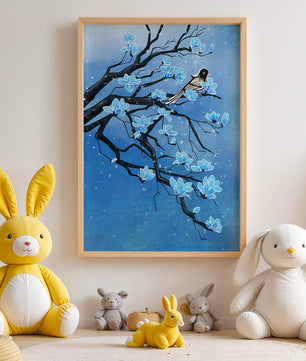 Bird on a branch with blue flowers against a snowy background