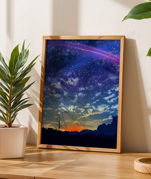 Starlit night sky with colorful sunset and silhouetted landscape