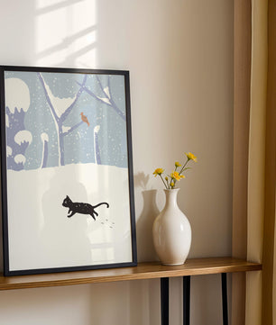 Paysage enneigé illustré avec un chat noir joueur et un oiseau dans un décor hivernal