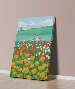 Woman with bicycle in vibrant tulip field by a lake