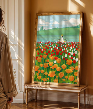 Woman with bicycle in vibrant tulip field by a lake