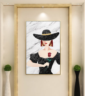 Elegant woman in wide-brimmed hat holding a rose on marble background
