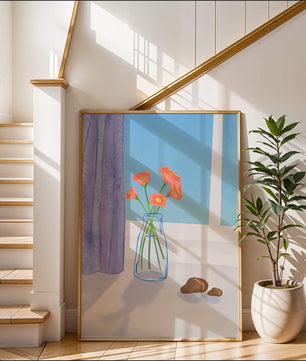 Jarrón con flores naranjas junto a una ventana con cortinas moradas