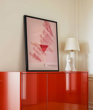 Elegante copa de cóctel roja sobre un fondo texturizado rosa