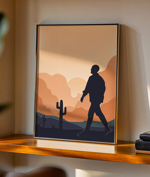 Silhouetted figure walking in desert landscape at sunset