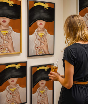 Femme avec un chapeau noir orné d’une touche dorée tenant un verre à cocktail