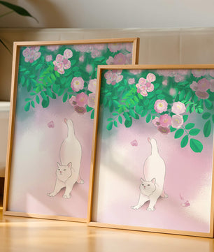 White cat stretching beneath blooming flowers in a pastel garden setting